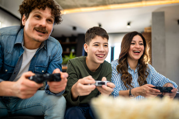 Rodzina Latynosów grająca w gry wideo ze swoimi kontrolerami. - Zdjęcie, obraz
