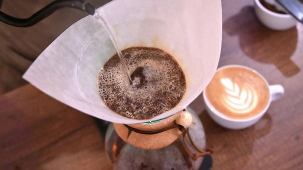 Barista wlewa wodę do filtra z kawą, parząc kawę. Alternatywne metody parzenia kawy - Zdjęcie, obraz