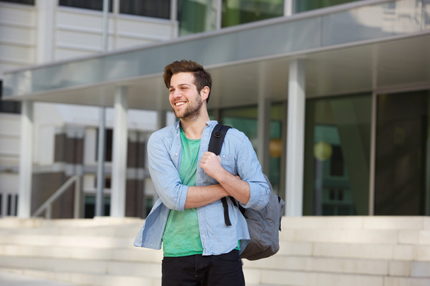 Gelukkig mannelijke college student permanent buiten met zak - Foto, afbeelding