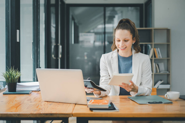 Conceito de análise de negócios, multitarefa profissional feminina alegre com um laptop e um notebook em uma mesa de escritório espaçosa - Foto, Imagem