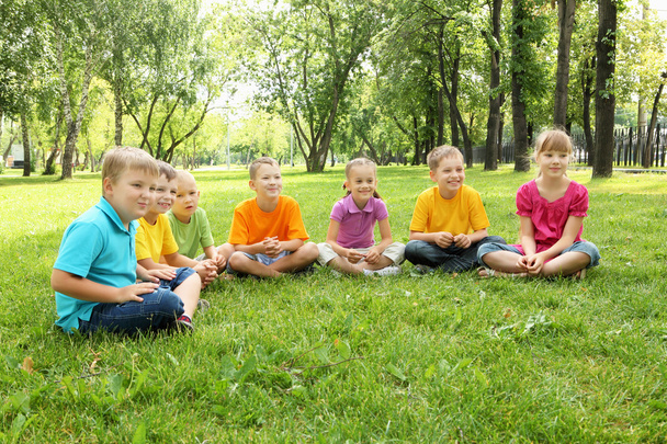 Group of children sitting together in the park - Photo, Image