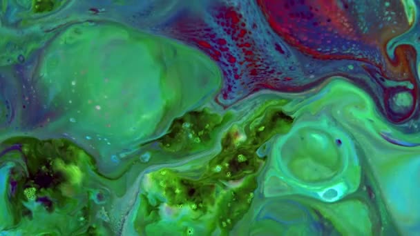 Este vídeo en stock presenta un primer plano extremo de una mezcla espesa de pinturas líquidas de colores que se extienden en la superficie en cámara lenta.  - Metraje, vídeo