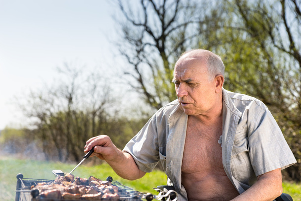 Serious Old Man Grilling at the Camp Area - Foto, Imagem