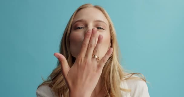 Happy, face or air kiss by woman in studio for thank you, gesture or sign on blue background. Hands, lips or portrait of flirting model with love expression for date, crush or valentines day romance. - Footage, Video