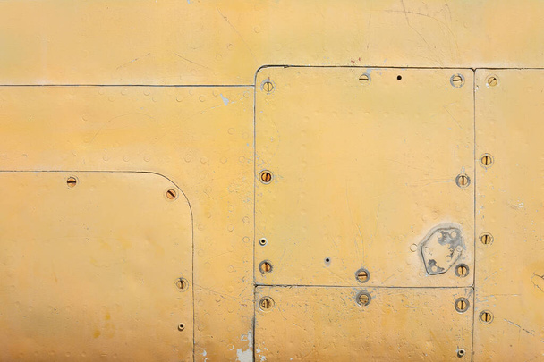 Dettagli della fusoliera di un vecchio velivolo. Vecchia superficie mimetica con vernice esfoliata e rivetti su un aereo militare. - Foto, immagini