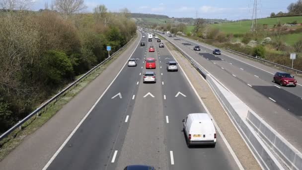 tráfico de autopistas del Reino Unido con camiones y vehículos que viajan por la carretera M5 Somerset en un día soleado en primavera hacia y desde la cámara desde el puente
 - Metraje, vídeo