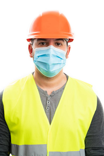 Adulto construtor masculino vestindo chapéu laranja e colete fluorescente amarelo traje de trabalho com sars descartáveis médicos ou cirúrgicos covid19 gripe máscara de proteção isolado no fundo branco - Foto, Imagem