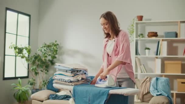 Happy Woman, Housewife Dancing While Ironing Clothes at Home. Young Woman Enjoy Housework. Regularity and Order: Completing Homework in a Timely and Organized Manner. - Footage, Video