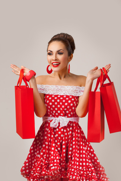 Happy Woman Holding Up Shopping Bags. Pin-up retro style. - Fotó, kép