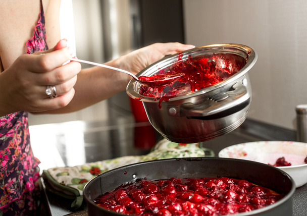 housewife making cherry jam in metal saucepan - Photo, Image