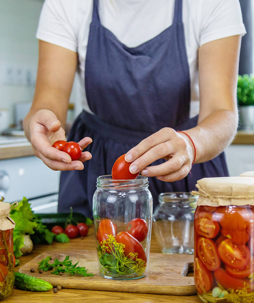 Vrouw die groenten inblikt in potten in de keuken. Selectieve focus. Voedsel. - Foto, afbeelding