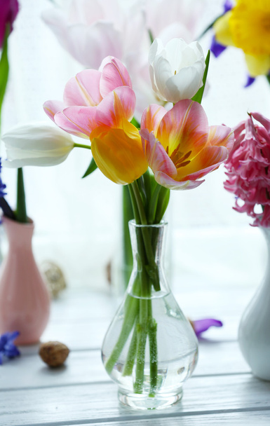 Beautiful bouquets of spring flowers on windowsill background - Foto, imagen