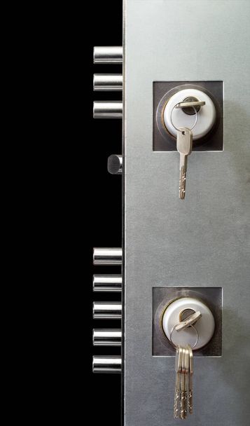 innen doppeltes Türschloss mit Schlüsseln isoliert auf schwarzem Hintergrund - Foto, Bild