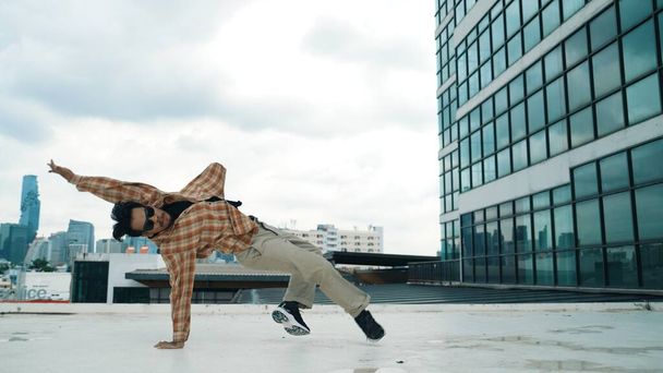 Boldog spanyol táncos alkalmi ruhát visel break tánc a városi városban. Energetikus hip-hop előadás. A koreográfus halad a freestyle ritmusban. Hip-hop tánc. Kültéri sport 2024. Hatálybalépés. - Fotó, kép
