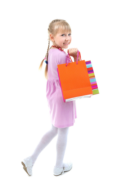 Beautiful little girl with shopping bags isolated on white - Foto, imagen