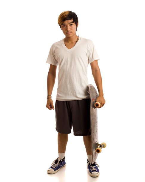 Young man with skateboard. Studio shot over white. - Foto, Imagem