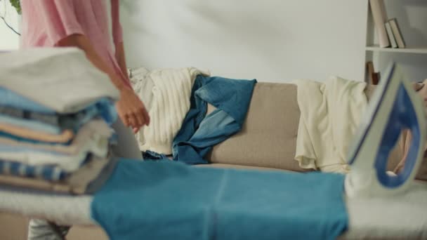 Mujer joven cansada cae en el sofá de debilidad después de planchar la lavandería. Estrés y sobrecarga: Acumulación de tareas, falta de plazos, falta de tiempo que conduce a la ansiedad y la fatiga. - Metraje, vídeo
