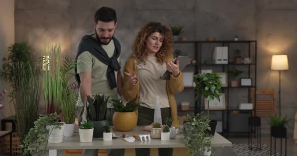 Paar Kaukasische man en vrouw vrouw vrouw en man planten bloemen samen verzorgen van thuis planten echte mensen huishoudelijk leven familie concept slow motion - Video