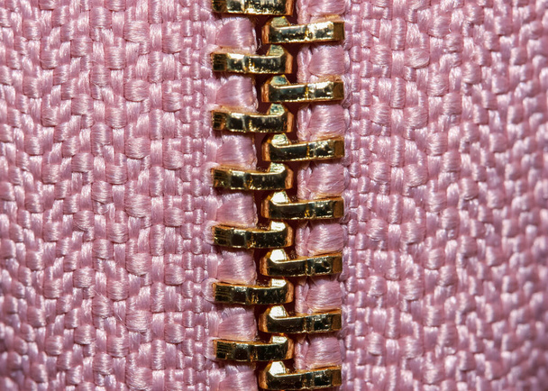 Close up view of brass zip on pink fabric.For background use. - Photo, Image