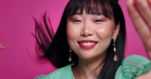 アジアの化粧品,メイク,ピンクのバックグラウンドで美のためのスタジオでブローキスで女性,顔,ビデオコール. コミュニケーション愛,ジェスチャー,自信のための女性,幸せ,モックアップスペース. - 映像、動画