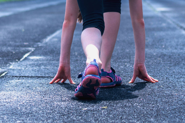 Молода жінка біжить ногами на дорозі крупним планом на взутті.  - Фото, зображення