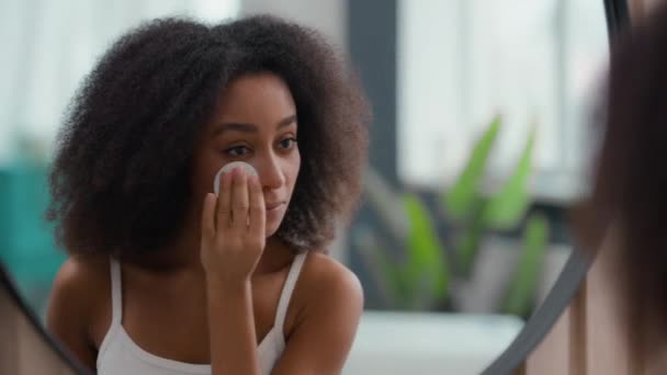 Egészséges gyönyörű afro-amerikai lány törölje arc pamut pad csinos mosolygós nő egészségügyi bőr tiszta mosás arc tisztító toner bőr eltávolítása make-up krém micellar víz akne - Felvétel, videó