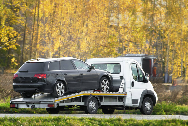 Un recupero del carro attrezzi con un pianale può trasportare il veicolo in sicurezza e fornire assistenza stradale. - Foto, immagini
