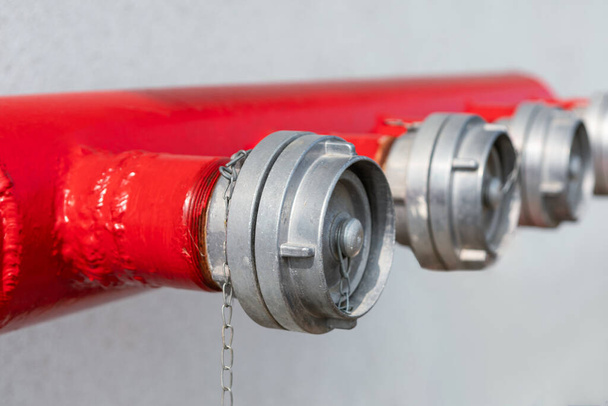 Beyaz arka planda kırmızı yangın hortumu ve su musluğu - Fotoğraf, Görsel
