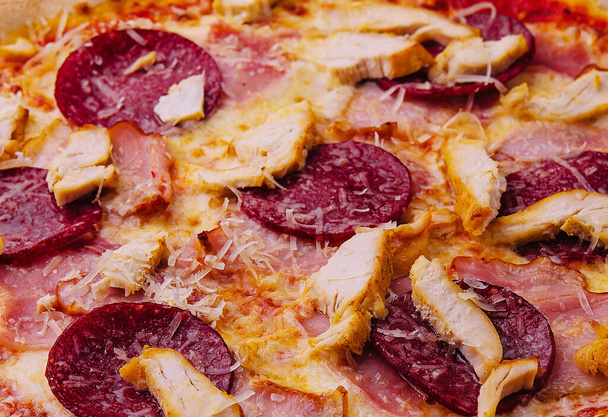 Pepperoni-Pizza mit Basilikum und Parmesan aus nächster Nähe - Foto, Bild