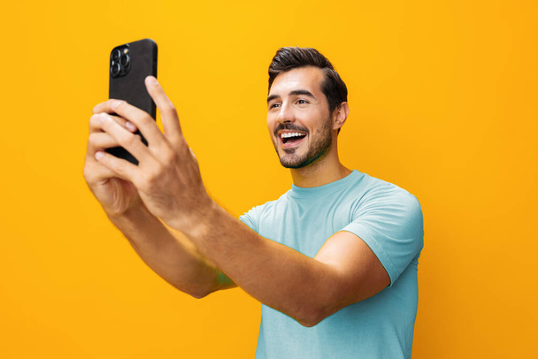 Kyberavaruus mies älypuhelin onnellinen elämäntapa puhelin liiketoiminnan mobiili viesti yllätys silmälasien osoittaa kopioida studio tekniikka keltainen puhelin tilaa hymyilevä muotokuva - Valokuva, kuva