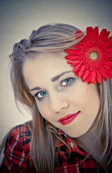 Portrait of young beautiful woman with red flower in her hair - Fotografie, Obrázek