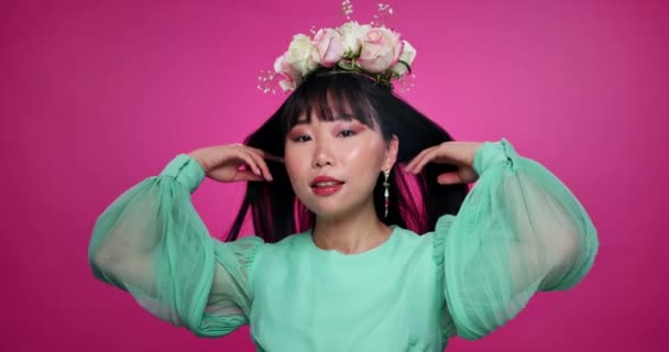 Gesicht, Schönheit und asiatische Frau mit Blumenkrone im Haar im Studio isoliert auf rosa Hintergrund. Porträt, Kranz und florale Kosmetik des natürlichen koreanischen Modells in Bio-Haut Make-up, Mode oder Lächeln. - Filmmaterial, Video