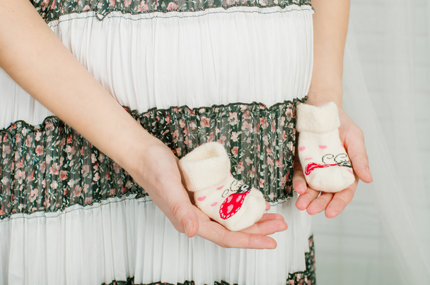 Baby socks in  hands of pregnant woman - Foto, imagen
