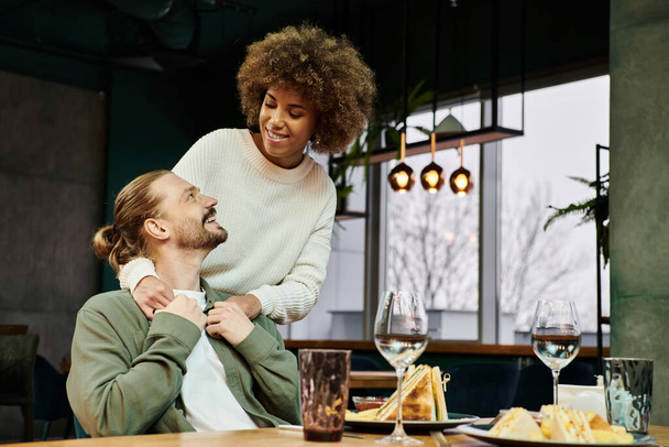 アフリカ系アメリカ人女性と男性がカフェでテーブルに座りながら会話に取り組んでいる.. - 写真・画像