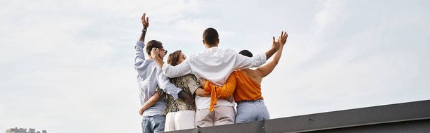 вид ззаду на чотирьох молодих міжрасових друзів у повсякденному міському вбранні, позує на даху, банер - Фото, зображення