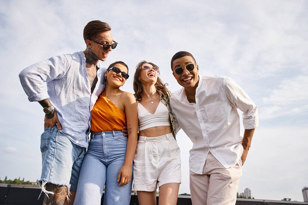 vrolijk divers goed uitziende vrienden met stijlvolle zonnebril poseren vrolijk op het dak samen - Foto, afbeelding