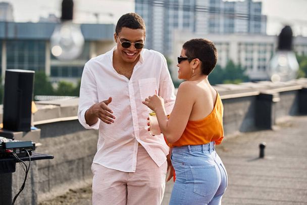 cheerful appealing diverse man and woman in casual attires chilling at rooftop party with cocktails - Фото, изображение