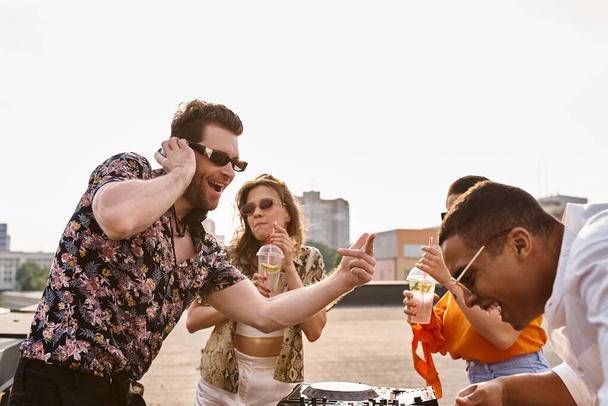 wesoły międzyrasowy dobrze patrząc przyjaciele pijąc koktajle i taniec do DJ zestaw na dachu party - Zdjęcie, obraz