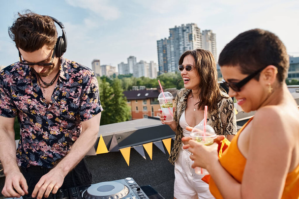 attrayant jeunes amis joyeux en tenue décontractée boire des cocktails et avoir du plaisir à la fête sur le toit - Photo, image
