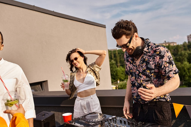 Neşeli, canlı giyinmiş, elinde kokteylle çatıda DJ 'in yanında parti veren güzel bir kadın. - Fotoğraf, Görsel