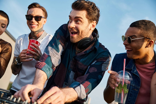 ομάδα χαρούμενων πολυφυλετικών φίλων πίνοντας κοκτέιλ και διασκεδάζοντας μαζί στο πάρτι στην ταράτσα - Φωτογραφία, εικόνα