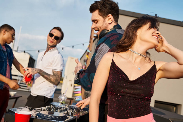 joyous long haired woman partying next to her cheerful multiracial friends while on rooftop - Photo, Image