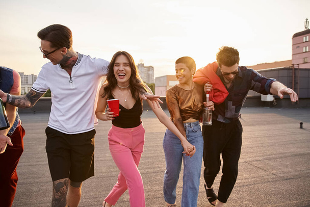 dronken vrolijke interraciale vrienden in stedelijke outfits met alcohol drankjes en plezier hebben op het feest - Foto, afbeelding