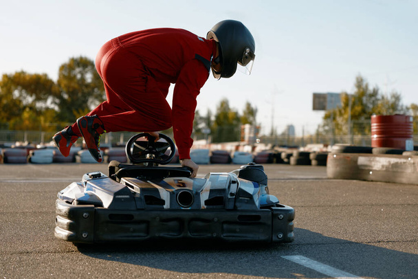 Hombre excitado conductor saltando en go-cart preparándose para el entretenimiento de carreras de velocidad. Concepto de hobby masculino - Foto, Imagen