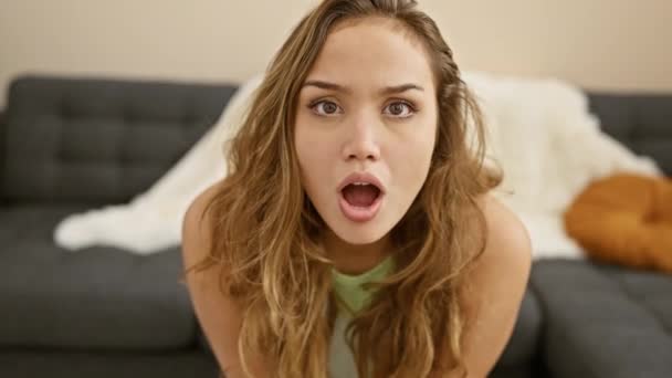 Young beautiful hispanic woman wearing casual clothes afraid and shocked with surprise and amazed expression, fear and excited face. at home - Footage, Video