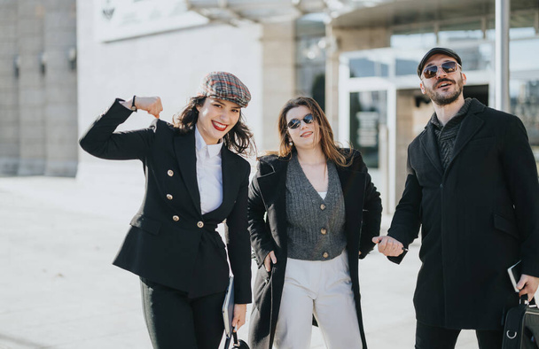 Μια ομάδα νέων επιχειρηματιών δείχνει ενθουσιασμό και ομαδικότητα καθώς περπατούν στην πόλη, απεικονίζοντας τη συνεργασία και την επιτυχία.. - Φωτογραφία, εικόνα