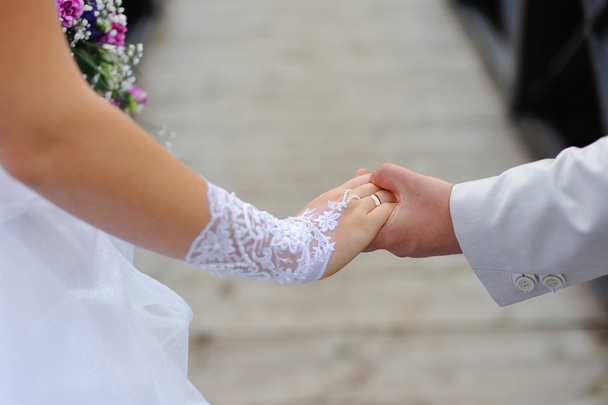 Νύφη και γαμπρός κρατώντας τα χέρια - Φωτογραφία, εικόνα