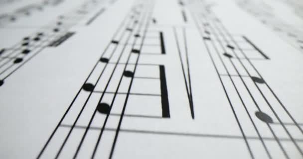 Μέλοντι γραμμένο με διαφορετικά σύμβολα σημείωμα στο φύλλο μουσικής. Σύνθεση μουσικών σημειώσεων για συναυλία σε λευκό χαρτί. Είδη μουσικής στην τάξη - Πλάνα, βίντεο