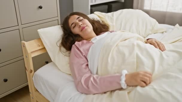 Egy fiatal spanyol nő élvezi a pihentető reggelt a hangulatos hálószobájában, boldogságot és kényelmet árasztva. - Felvétel, videó