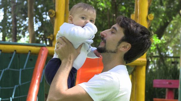 Apa tartja baba fia a szabadban játszótér park szerető autentikus kapcsolat - Fotó, kép
